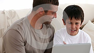 Father and son playing with a computer