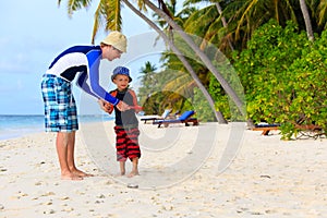 Father and son playing with flying disc at beach