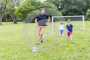 Father with son playing football on football pitch