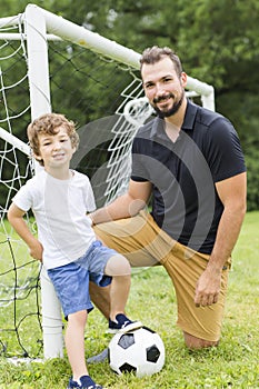 Father with son playing football on football pitch