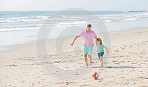 father and son playing football on summer beach with ball, best friends
