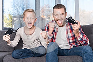 Father and son playing with joysticks