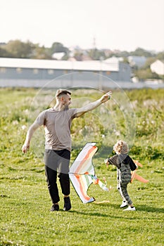 Father and son playing with a kite on summer outdoors