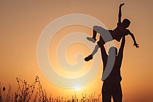 Father and son playing in the park at the sunset time