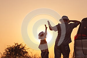 Father and son playing in the park at the sunset time