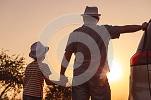 Father and son playing in the park at the sunset time