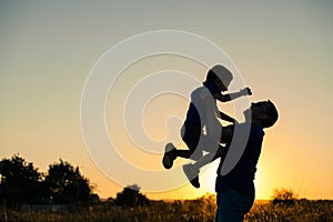 Father and son playing in the park at the sunset time