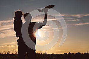 Father and son playing in the park at the sunset time