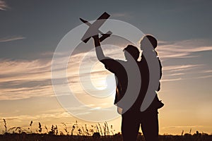 Father and son playing in the park at the sunset time