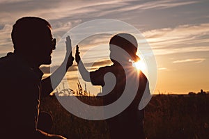 Father and son playing in the park at the sunset time