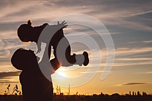 Father and son playing in the park at the sunset time