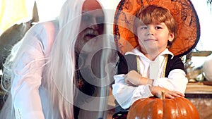 Father and son playing scary Halloween games at home. Grandpa and grandson with pumpkin together as preparation for