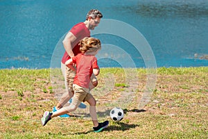 Father and son playing soccer football together. Father and son hours practicing passing kicking soccer ball. Dad and