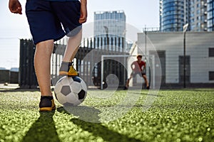 Father and son playing soccer, practicing shots on goal at stadium