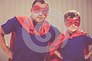 Father and son playing superhero outdoors at the day time.