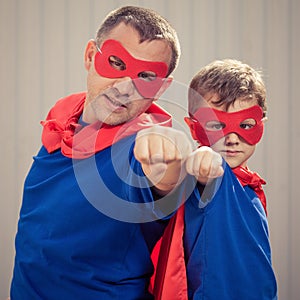 Father and son playing superhero outdoors at the day time.