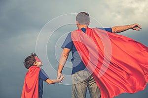 Father and son playing superhero outdoors at the day time.