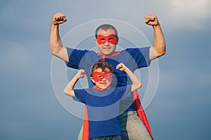 Father and son playing superhero outdoors at the day time.