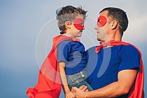 Father and son playing superhero outdoors at the day time.