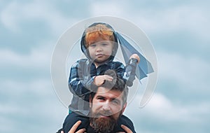 Father and son playing together. Father and son enjoying outdoor. Freedom to Dream - Joyful Boy Playing With Paper