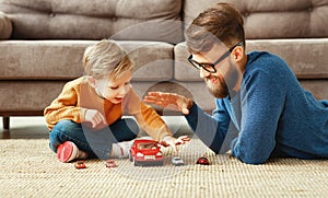 Father and son playing the toys cars at home