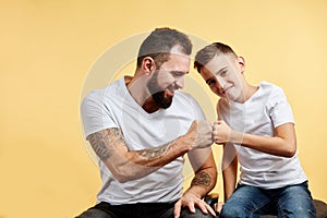 Father and son with pleasant smile give fist bump to each other