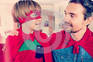 Father and son pretending to be superhero in living room