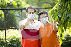 Father and son with protective face mask looking at camera