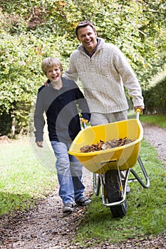 Father and son pushing wheelbarrow