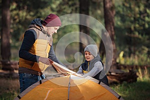 father and son putting up tent