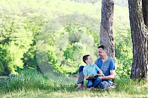 father and son reading bible book