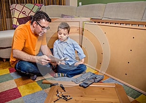 Father and son reading instructions to assemble