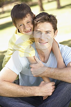 Father And Son Relaxing In Park Together