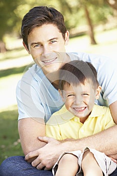 Father And Son Relaxing In Park Together