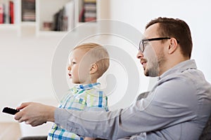 Father and son with remote watching tv at home