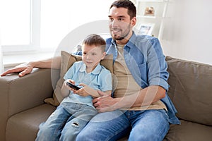 Father and son with remote watching tv at home