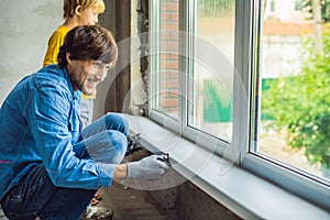 Father and son repair windows together. Repair the house yourself