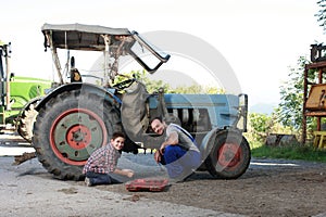 Father and son repairing a tractor