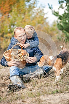 Father and son rest on forest glade after mushrooms pick