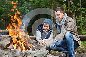 Father and son roasting marshmallow over campfire