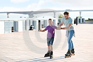 Father and son roller skating on street