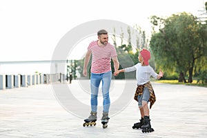 Father and son roller skating on street