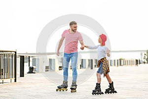 Father and son roller skating on street