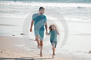 Father and son running on sea. Concept of friendly family and of summer vacation.