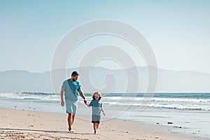 Father and son running on summer beach. Dad and child having fun outdoors. Family travel, vacation, father's day