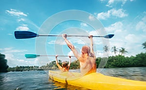 Father and son are sailing in the canoe in lagoon in sunny day