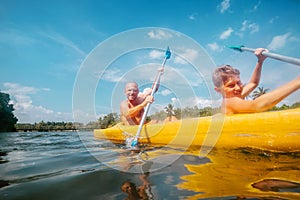 Father and son are sailing in the canoe in tropical lagoon