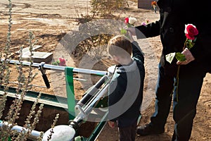 Father and Son Say Goodbye to a Loved One By Throwing Roses on a