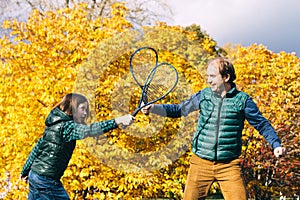 A father and son of school age with badminton racket are talking