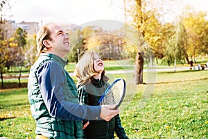 A father and son of school age are talking with badminton racket